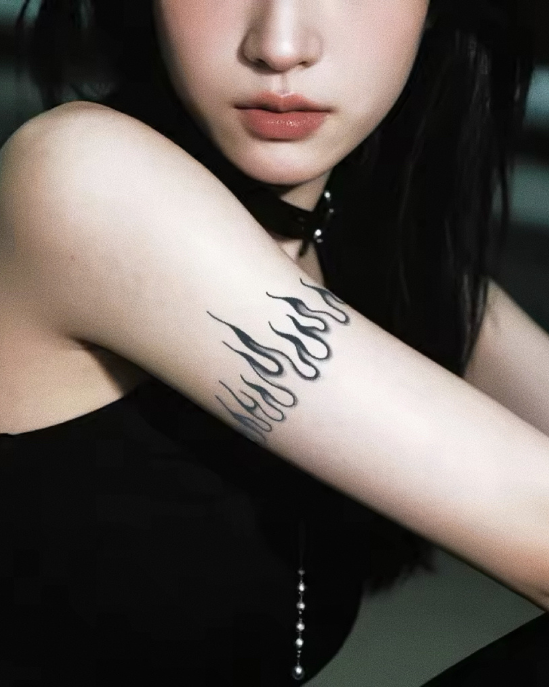 Person with a Flames: Rising Fire — Semi-Permanent Tattoo on their arm, wearing a black top.